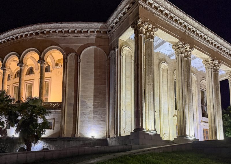Lado Meskhishvili Theatre in Kutaisi lit up at night, with its columns and arched windows